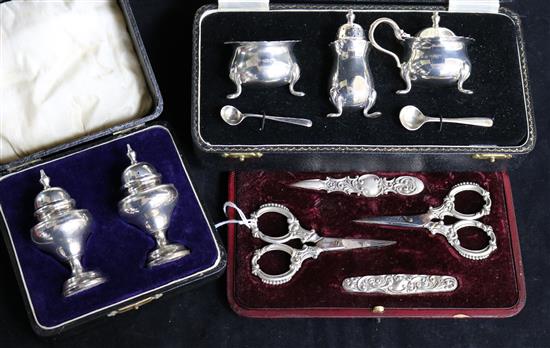 Two cased silver condiment sets and a cased silver mounted manicure set.